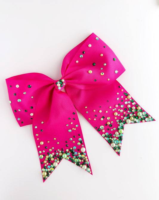 A pink ribbon with green and white beads on it, creating a colorful and decorative design.