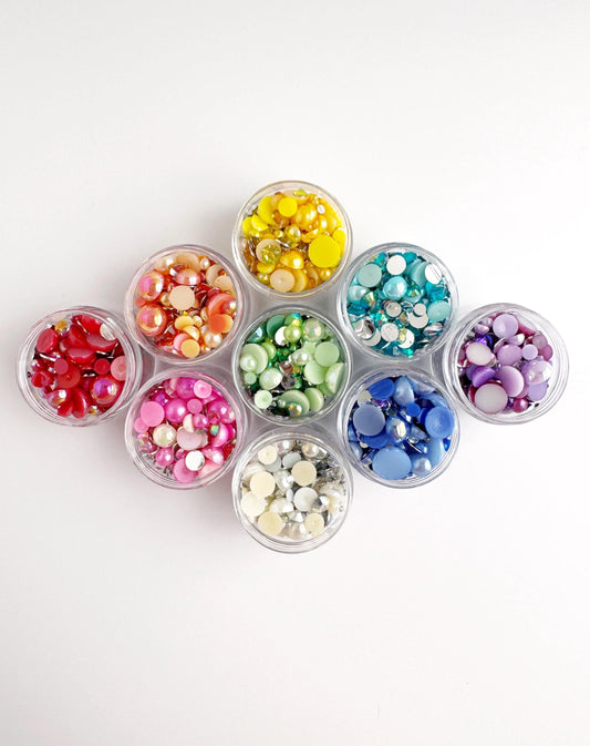 A collection of small, clear containers filled with colorful beads or buttons arranged in a visually appealing pattern.