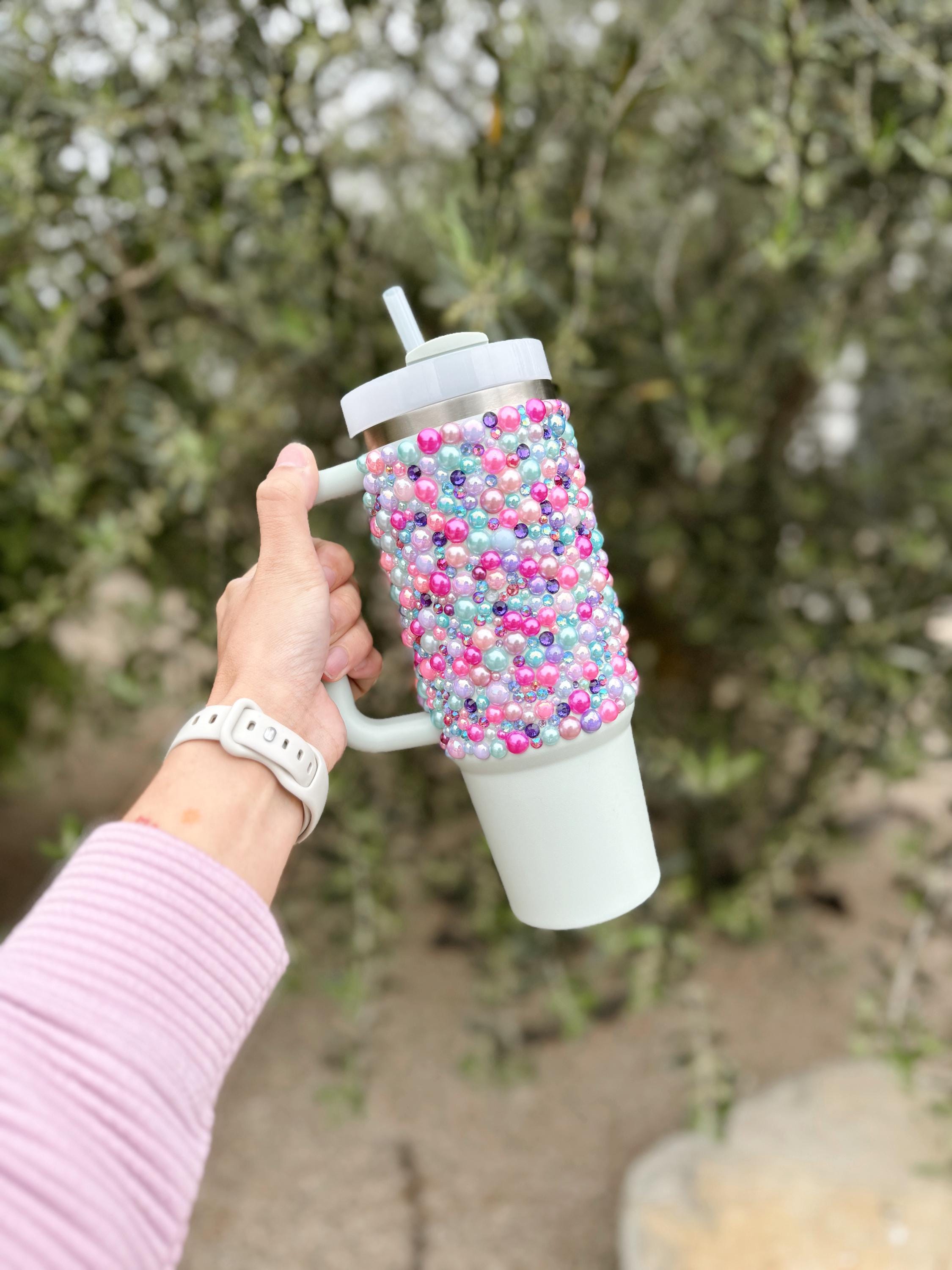 a person holding a coffee cup with sprinkles on it