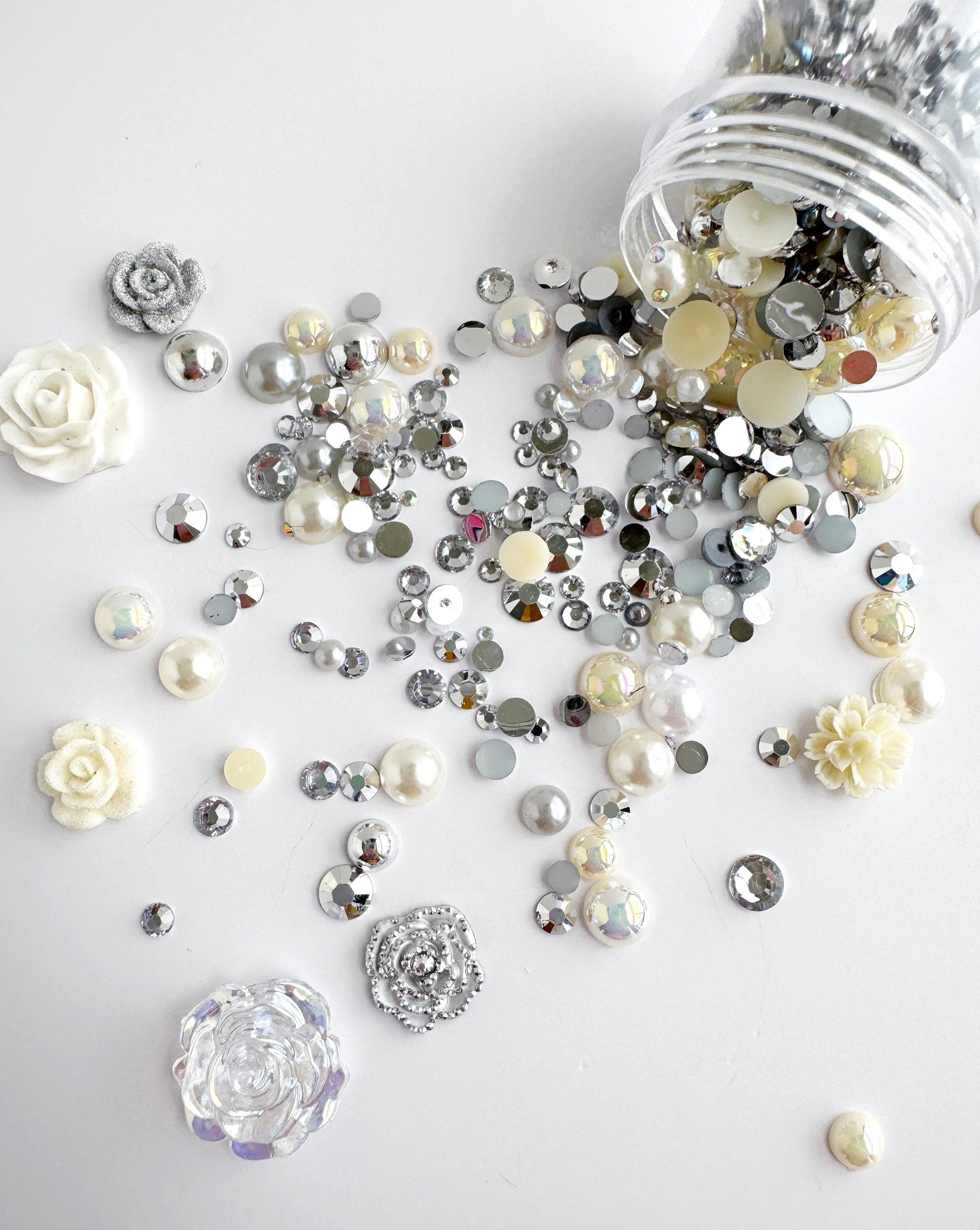 a collection of various shiny, metallic, and crystal-like objects scattered across a white background.