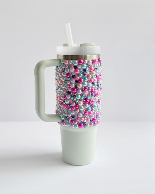 a coffee cup with beads and a straw sticking out of it
