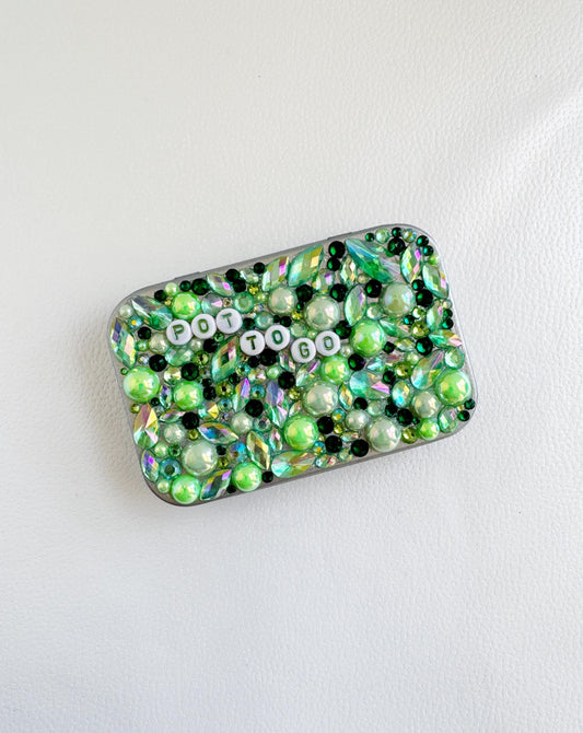 a cell phone covered in green and white beads