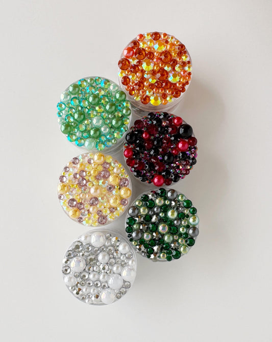 A collection of colorful beads or sequins arranged in a row, with each bead or sequin having a unique color and pattern.