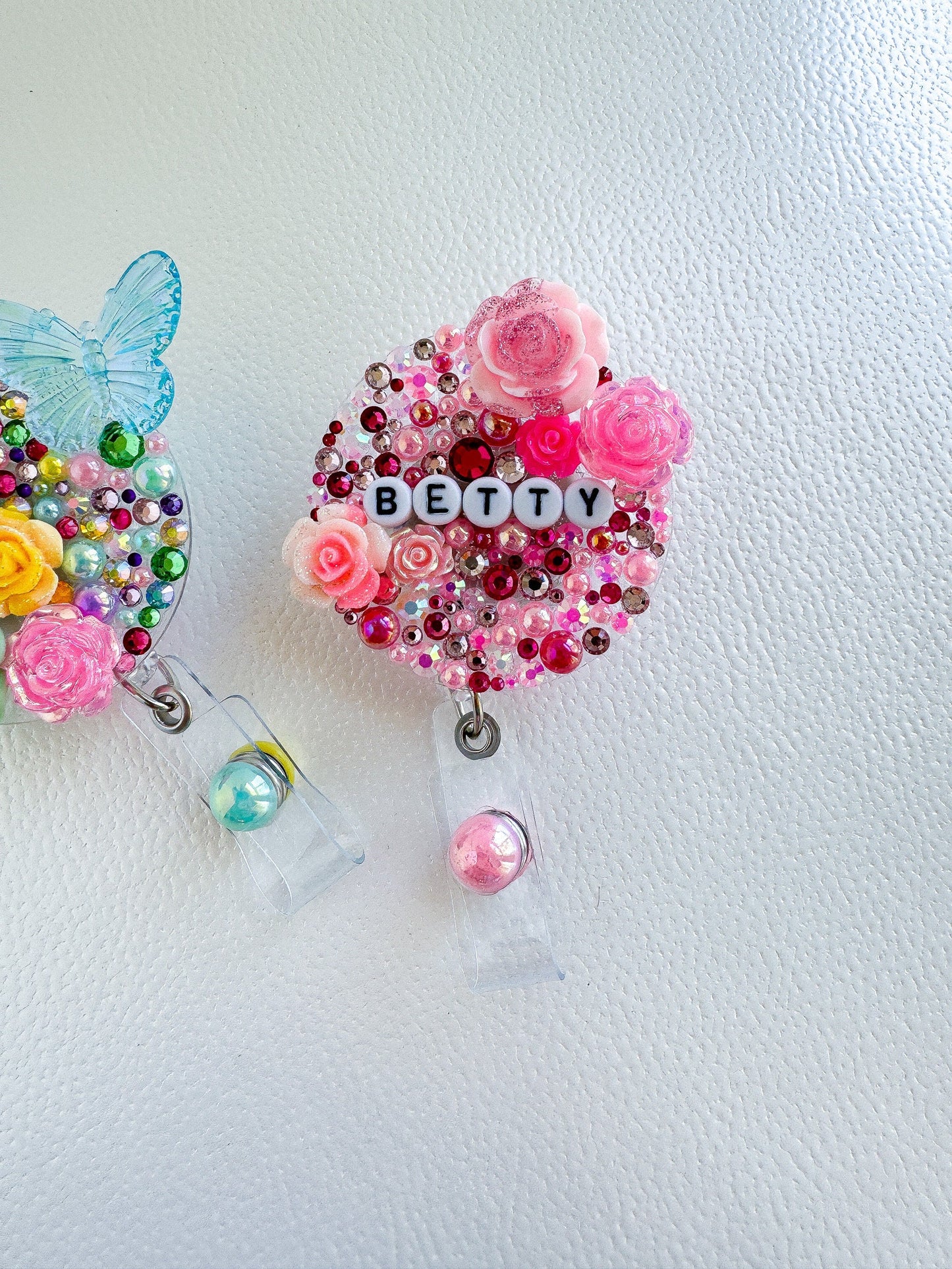 a pair of pacifier clips with beads and flowers on them