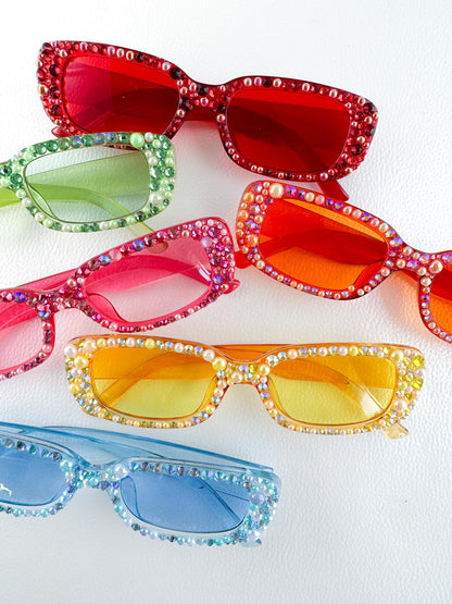 four pairs of colorful sunglasses with crystals on them