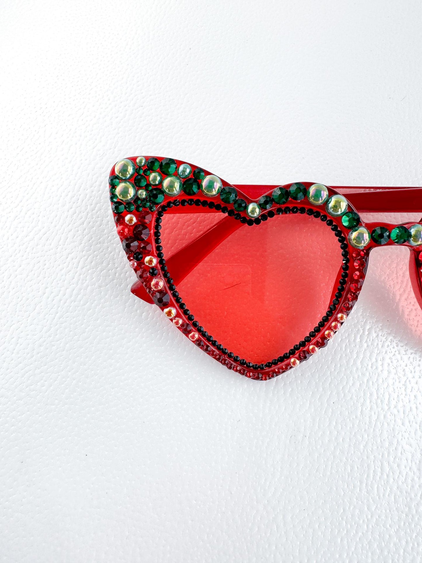 a pair of red sunglasses with a heart shaped frame