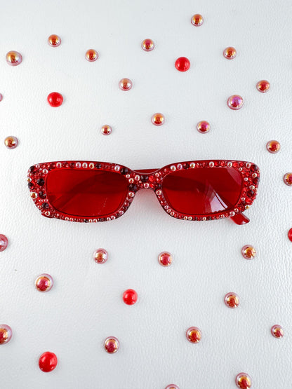 a pair of red sunglasses sitting on top of a table