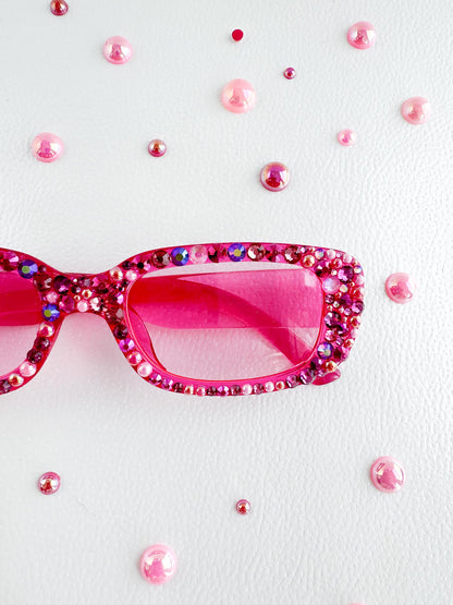 a pair of pink sunglasses sitting on top of a table