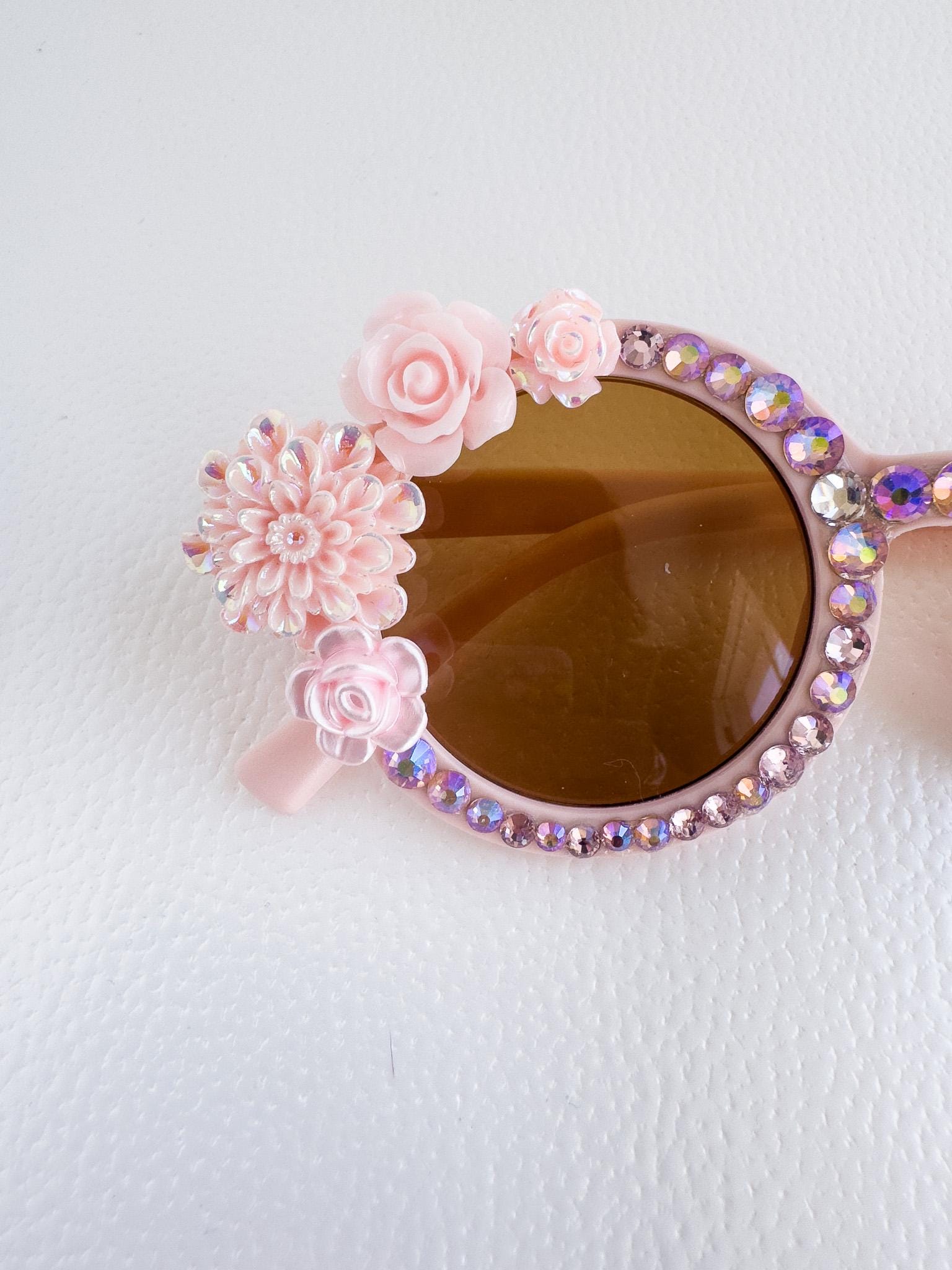 a pair of pink sunglasses with flowers on them