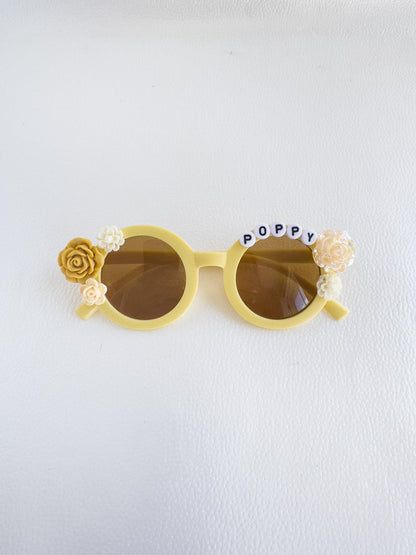 a pair of yellow sunglasses with flowers on them